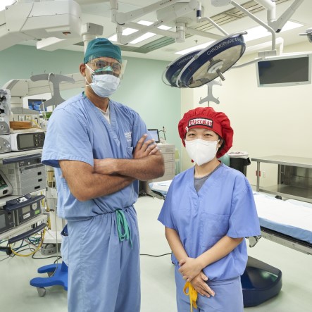 Male and female healthcare professionals wearing masks standing in operating room